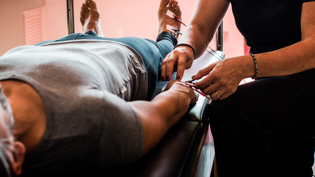 Close-up of adhesive stickers and red and black electrode clips on a client’s hand and wrist during a Body MOT